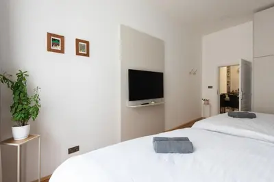 a bedroom with two white beds and a flat screen tv at Zen Garden in Prague