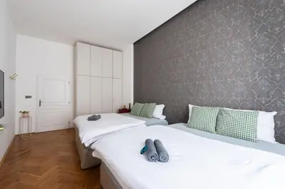 a bedroom with two beds and a wall at Zen Garden in Prague