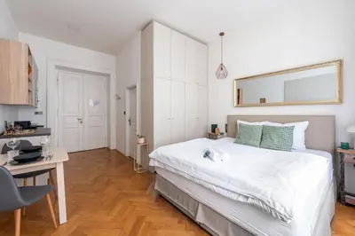 a bedroom with a large white bed and a desk at Zen Garden in Prague