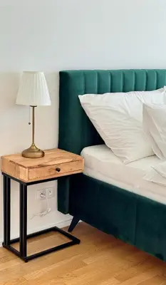 a bed with a side table with a lamp on it at Spacious urban apartment with terrace in Prague