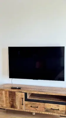 a flat screen tv sitting on top of a wooden entertainment center at Spacious urban apartment with terrace in Prague