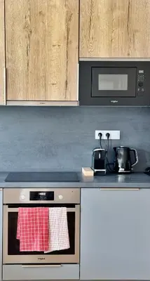 a kitchen with a stove top oven with a microwave at Spacious urban apartment with terrace in Prague