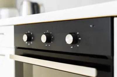 a close up of an oven with black knobs at Rentero Central Two Bedroom Apartment in Prague - Two bathroom - Parking in Prague
