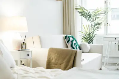 a white living room with a white couch and a plant at Rentero Central Two Bedroom Apartment in Prague - Two bathroom - Parking in Prague