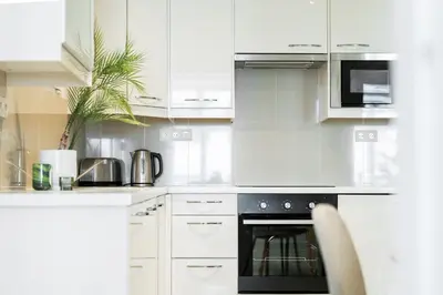 a kitchen with white cabinets and a black oven at Rentero Central Two Bedroom Apartment in Prague - Two bathroom - Parking in Prague