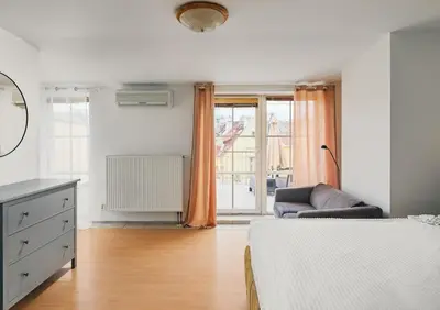 a bedroom with a bed and a couch and a window at Beautiful OLD TOWN penthouse in Prague