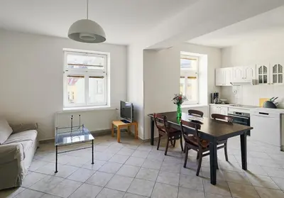 a living room with a dining table and a kitchen at Beautiful OLD TOWN penthouse in Prague
