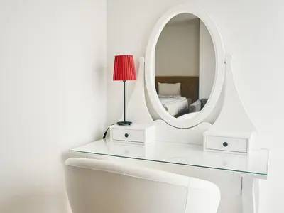 a white dressing table with a mirror and a bed at Beautiful OLD TOWN penthouse in Prague