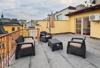 a patio with chairs and tables on a balcony at Beautiful OLD TOWN penthouse in Prague