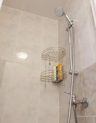 a bathroom with a shower with a rack of toiletries at Just 3 min Walk Old Town Center private room A in Prague