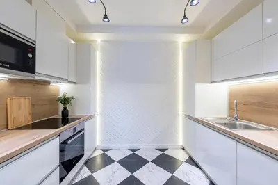 a kitchen with white cabinets and a black and white checkered floor at Casa Nuova in Prague