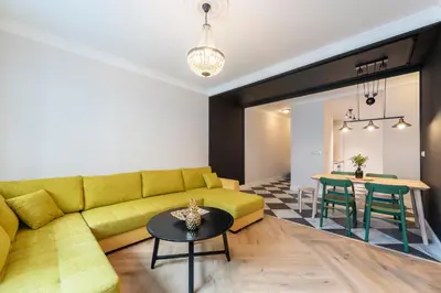 a living room with a yellow couch and a table at Casa Nuova in Prague