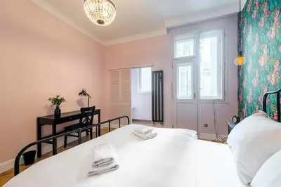 a bedroom with a large white bed and a window at Casa Nuova in Prague