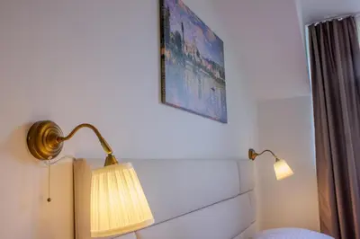 a bedroom with a lamp and a picture on the wall at Cozy Apartment in central Prague near Wenceslas Sq in Prague