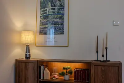 a table with a lamp and a picture on the wall at Cozy Apartment in central Prague near Wenceslas Sq in Prague