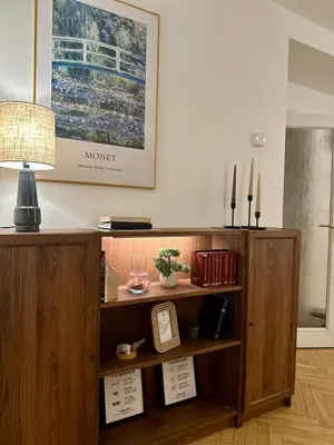 a book shelf with a lamp and a picture on the wall at Cozy Apartment in central Prague near Wenceslas Sq in Prague