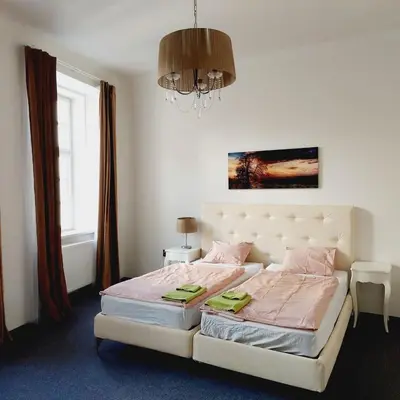 a bedroom with a bed with pink sheets and a chandelier at Just 3 min Walk Old Town Center private room E in Prague