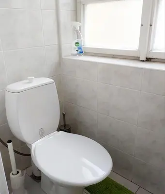 a white toilet in a bathroom with a window at Just 3 min Walk Old Town Center private room C in Prague
