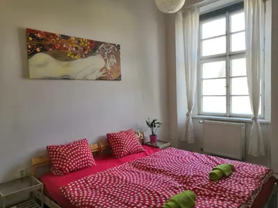 a bedroom with a red bed with pillows on it at 3 min Walk Old Town Center private room A in Prague