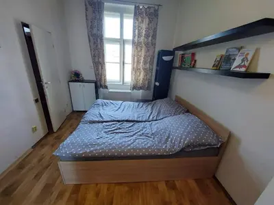 a bedroom with a bed with a blue comforter and a window at Apartment Near City Center! in Prague