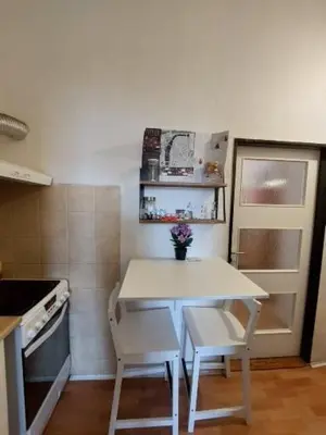 a small kitchen with a white table and chairs at Apartment Near City Center! in Prague