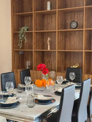 a dining room table with chairs and a long table with wine glasses at Entire 2nd floor of Villa with 3bedroom with large garden,BBQ,pool,sauna,free parking in Popovičky