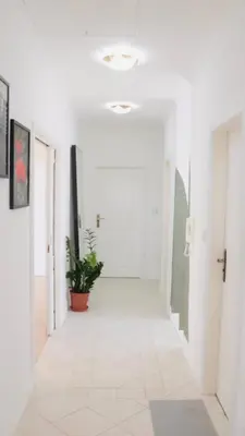 a hallway with white walls and a potted plant at Entire 2nd floor of Villa with 3bedroom with large garden,BBQ,pool,sauna,free parking in Popovičky