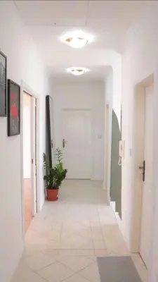 a hallway with white walls and a white tile floor at Entire 2nd floor of Villa with 3bedroom with large garden,BBQ,pool,sauna,free parking in Popovičky