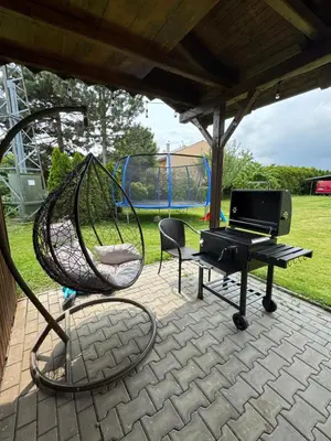 a hammock and a piano on a patio at Entire 2nd floor of Villa with 3bedroom with large garden,BBQ,pool,sauna,free parking in Popovičky