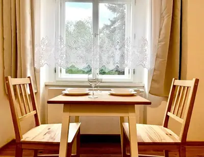 a table with a wine glass and a window at The Hrad nest in Prague