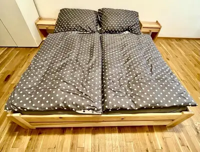 a bed with polka dot sheets on a wooden platform at The Hrad nest in Prague