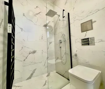 a bathroom with a glass shower with a toilet at The Hrad nest in Prague