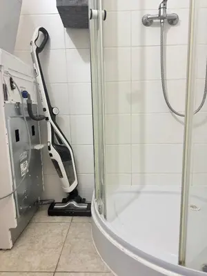 a walk in shower with a vacuum in a bathroom at Kamenicka new! in Prague