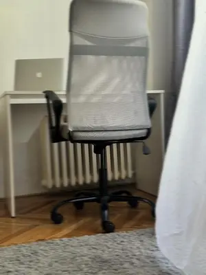 a white office chair sitting next to a bed at Apartment 23 in Prague