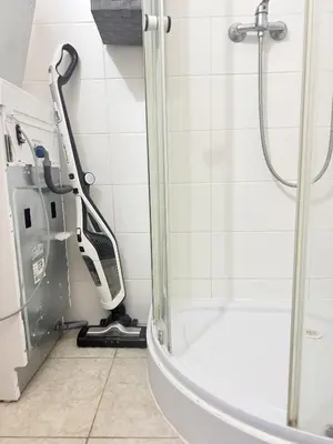 a walk in shower with a shower cleaner in a bathroom at Apartment 23 in Prague