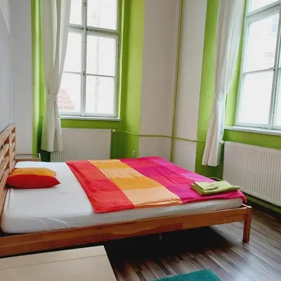a bed in a room with green walls and windows at Charles bridge, Old town3 Min walk Private Room E in Prague