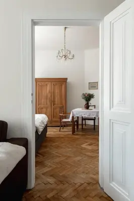 a living room with a table and a chandelier at Authentically stylish apartment with a mystical view GOLEM in Prague