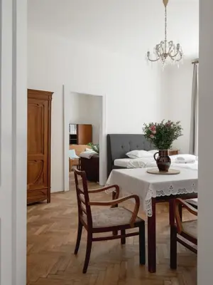 a living room with a table and chairs and a bedroom at Authentically stylish apartment with a mystical view GOLEM in Prague