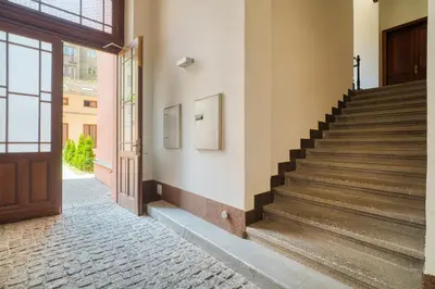 a staircase in a building with a wooden door at Fügner's apartment by Rentez in Prague