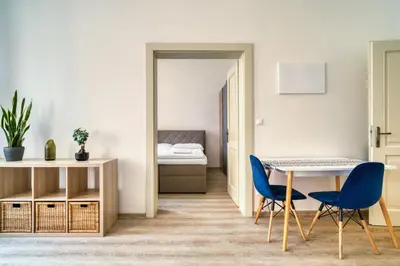 a room with a table and two blue chairs at Fügner's apartment by Rentez in Prague