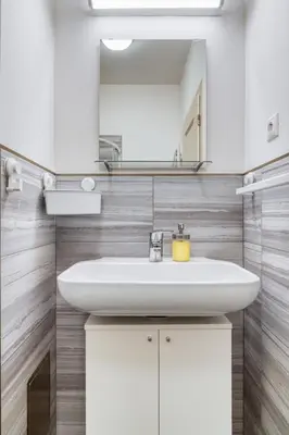 a bathroom with a white sink and a mirror at Fügner's apartment by Rentez in Prague
