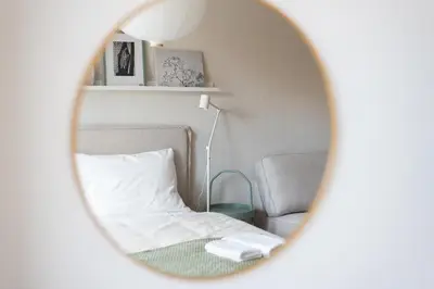 a room with a bed and a chair and a mirror at Stylish and Comfortable Studio in Prague