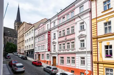 a row of buildings on a city street with cars parked at Good Mood in the Zizkov Hood Prague in Prague