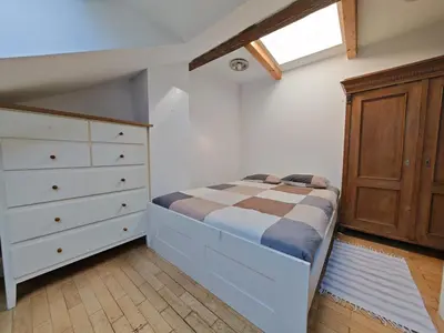a bedroom with a bed and a wooden dresser at Elegant and Spacious 4BR Loft in Charming Vinohrady in Prague