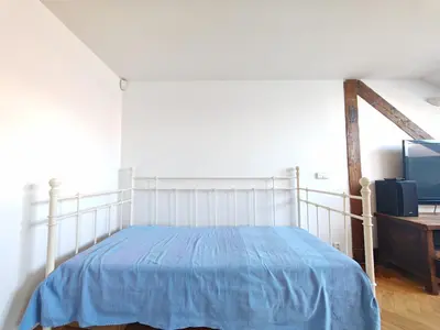 a bedroom with a bed and a desk and a tv at Elegant and Spacious 4BR Loft in Charming Vinohrady in Prague