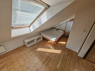 a attic room with a bed and a window at Elegant and Spacious 4BR Loft in Charming Vinohrady in Prague