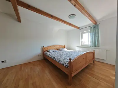 a bedroom with a wooden bed and a window at Elegant and Spacious 4BR Loft in Charming Vinohrady in Prague