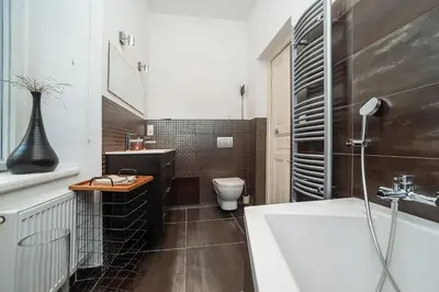 a bathroom with a tub and a toilet and a sink at Museum Quarter Elegance Suite in Prague