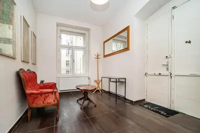 a living room with a red chair and a table at Museum Quarter Elegance Suite in Prague