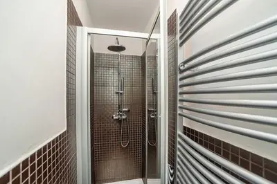 a shower with a glass door in a bathroom at Museum Quarter Elegance Suite in Prague